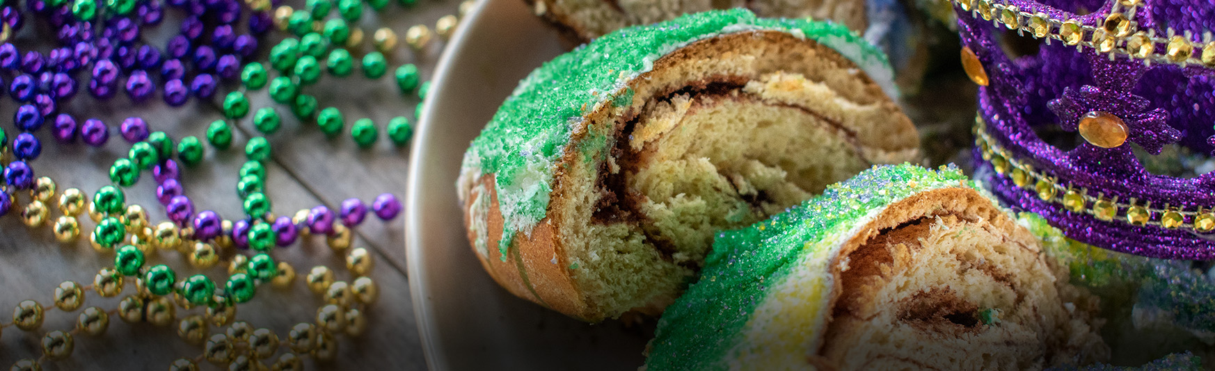 Close up of a colourful King Cake and beads